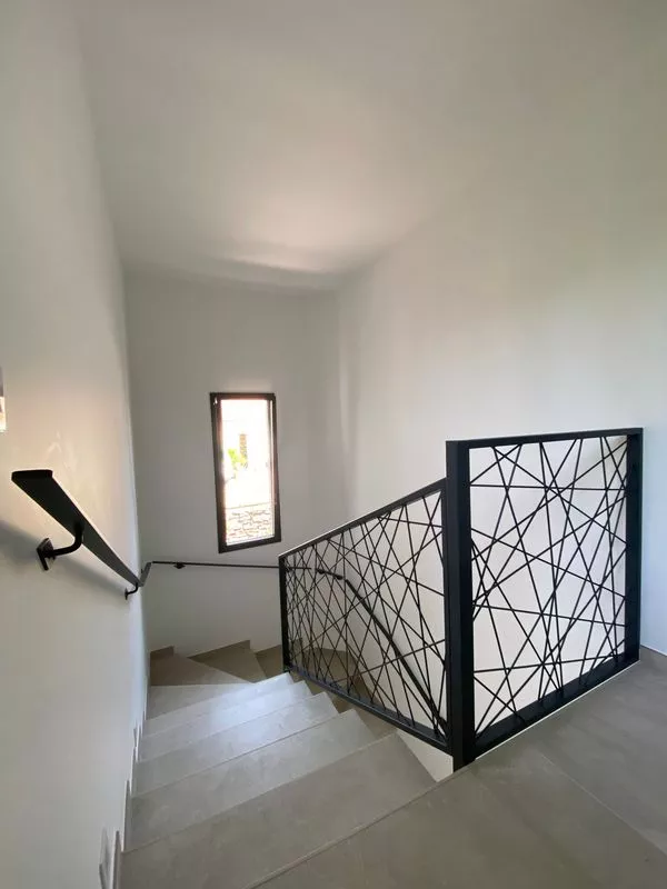 Main courante sur mesure en acier au design moderne et épuré en fer plat, avec barre, rampe et poignée murale pour escalier, réalisée par la ferronnerie et métallerie FIMSAI à Carry-le-Rouet