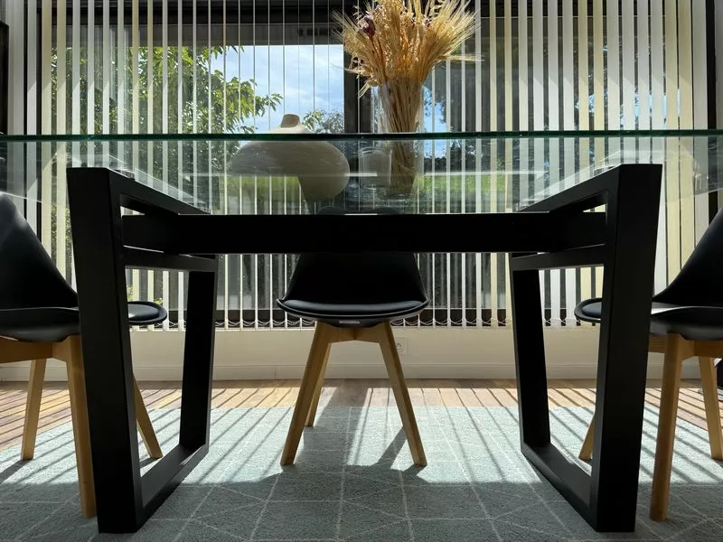 Pied de table industriel design sur mesure en acier avec structure originale en tube métallique et plateau en verre moderne, réalisé par la ferronnerie et métallerie FIMSAI à Ensuès-la-Redonne